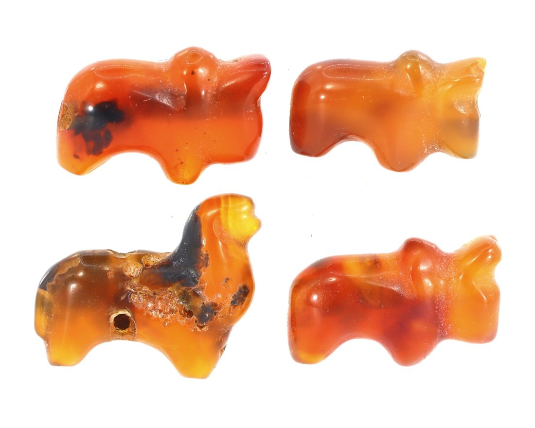 A Quartet of Carnelian Zoomorphic Amulets, Possibly Late Period to Ptolemaic: Crafted from the warm, translucent hues of carnelian, these four amulets, each 0.8 cm by 0.6 cm, feature zoomorphic forms likely inspired by Ancient Egyptian symbolism. The amulets are characteristic 