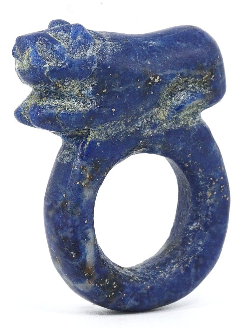 A Coptic Egyptian Lapis Lazuli Lion Ring, 1st Millennium CE: This lapis lazuli ring from Coptic Egypt features a finely carved lion, a potent symbol of power and protection throughout ancient civilizations. The lapis lazuli's deep blue tone, interspersed with p