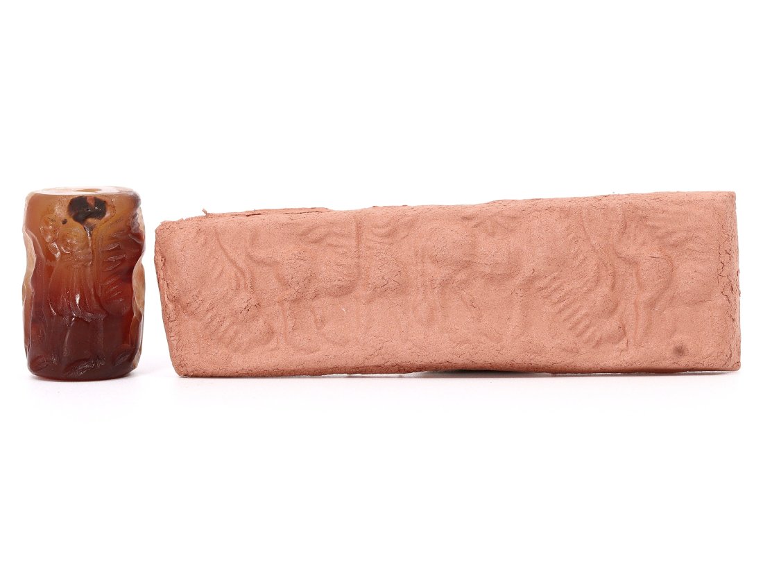 An Egyptian Agate Cylinder Seal, Late Period, circa 664-332 B.C.: This exquisite Egyptian cylinder seal, measuring a mere 2.5 cm in length, is a testament to the remarkable craftsmanship of the Late Period. Carved from agate, a stone revered for its durability and b