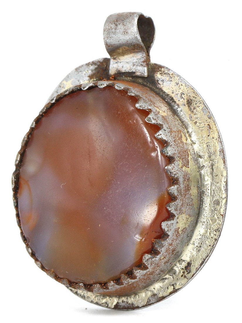 A Victorian Agate and Silver Locket, Late 19th Century: This elegant locket, with its warm-hued agate centerpiece encased in finely worked silver, is a quintessential accessory of the Victorian era. The locket, measuring 4 cm by 3 cm, features a smooth, po