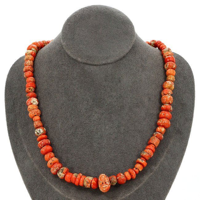 A Tibetan Antique Necklace with Authentic Red Coral Beads: This authentic Tibetan necklace, strung with red coral beads, is a striking artifact of cultural significance. Spanning a length of 20 inches, the beads vary in size and shape, each uniquely marred by
