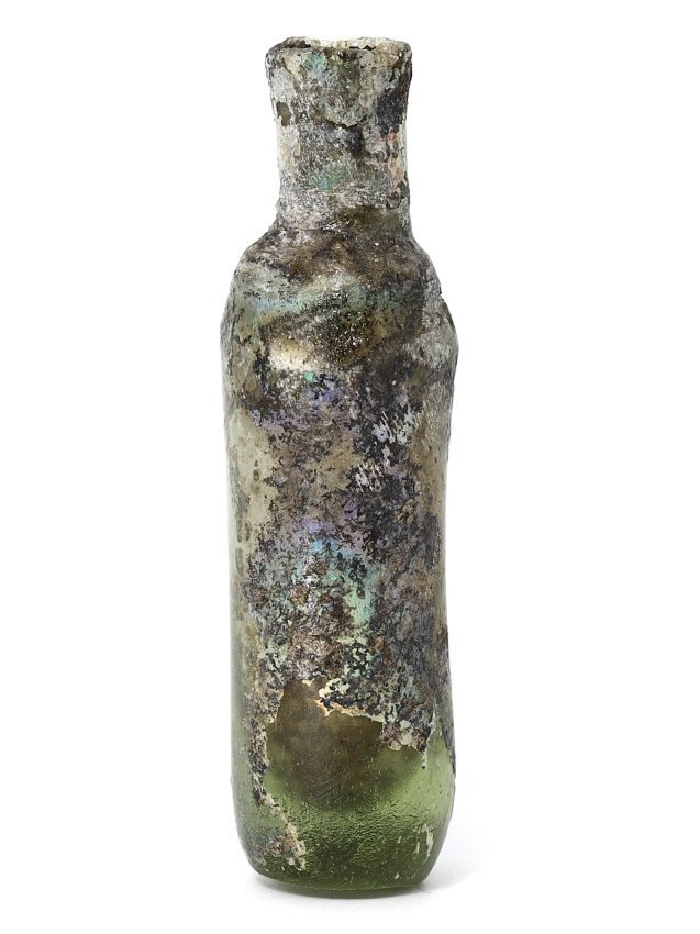 A Roman Glass Vessel Bottle, 1st-7th Century AD: This Roman glass vessel bottle, dating from the 1st to 7th century AD, exemplifies the enduring art of glassmaking in antiquity. Standing 6 cm tall and with a diameter of 1.5 cm, it possesses a slende