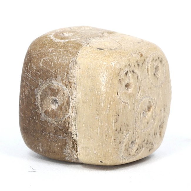 Ancient Roman Bone Dice, 1st-4th Century AD: This Roman bone dice, dating from the 1st to the 4th century AD, measures 1.1x0.8 cm. Dice like this were used in various games of chance and were a common feature of Roman daily life, from the legion