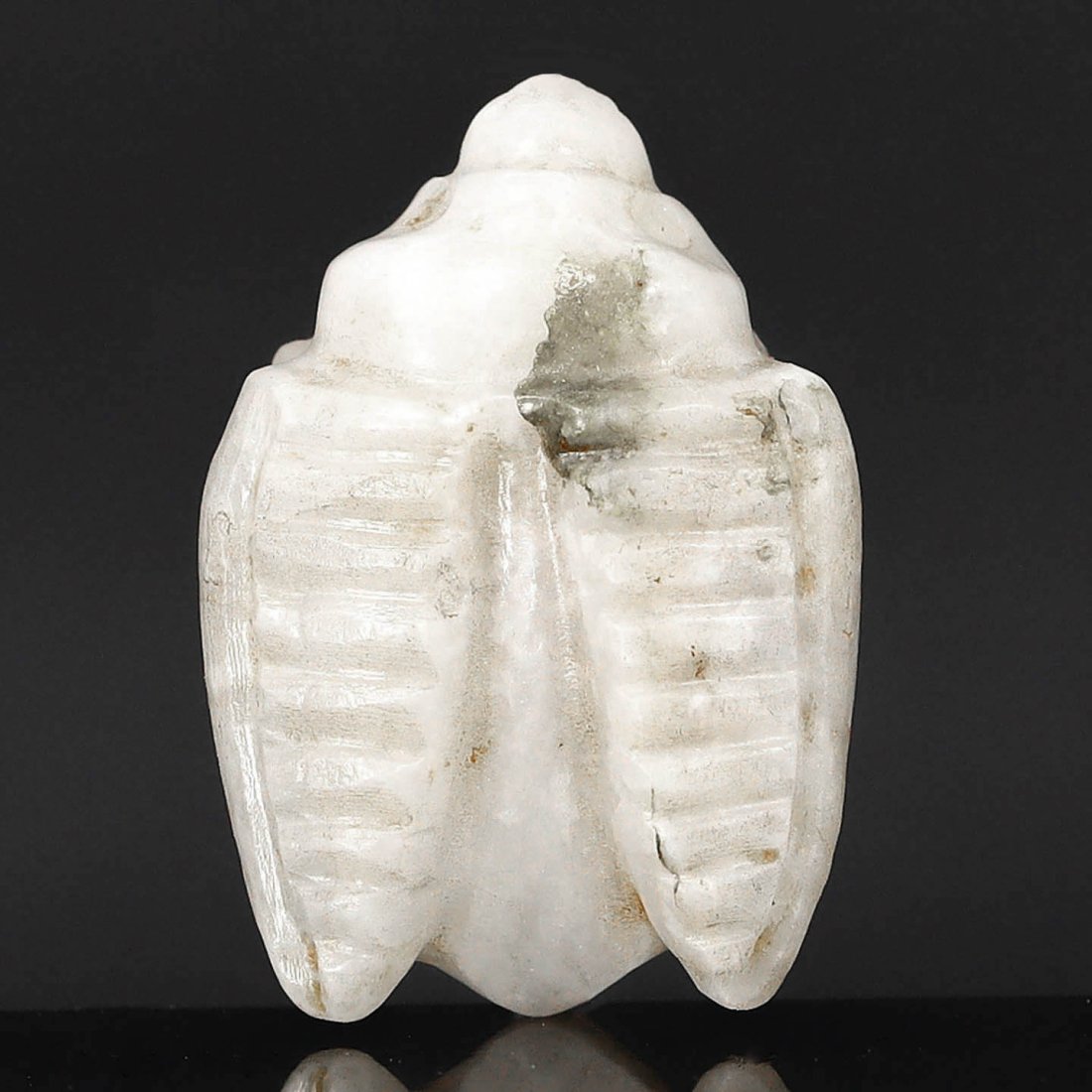 An Egyptian Alabaster Fly Amulet, New Kingdom, 1550-1070 B.C.: Representing the New Kingdom period, this delicate alabaster fly amulet exemplifies the Egyptian belief in the protective and regenerative powers of such talismans. Flies were associated with persiste