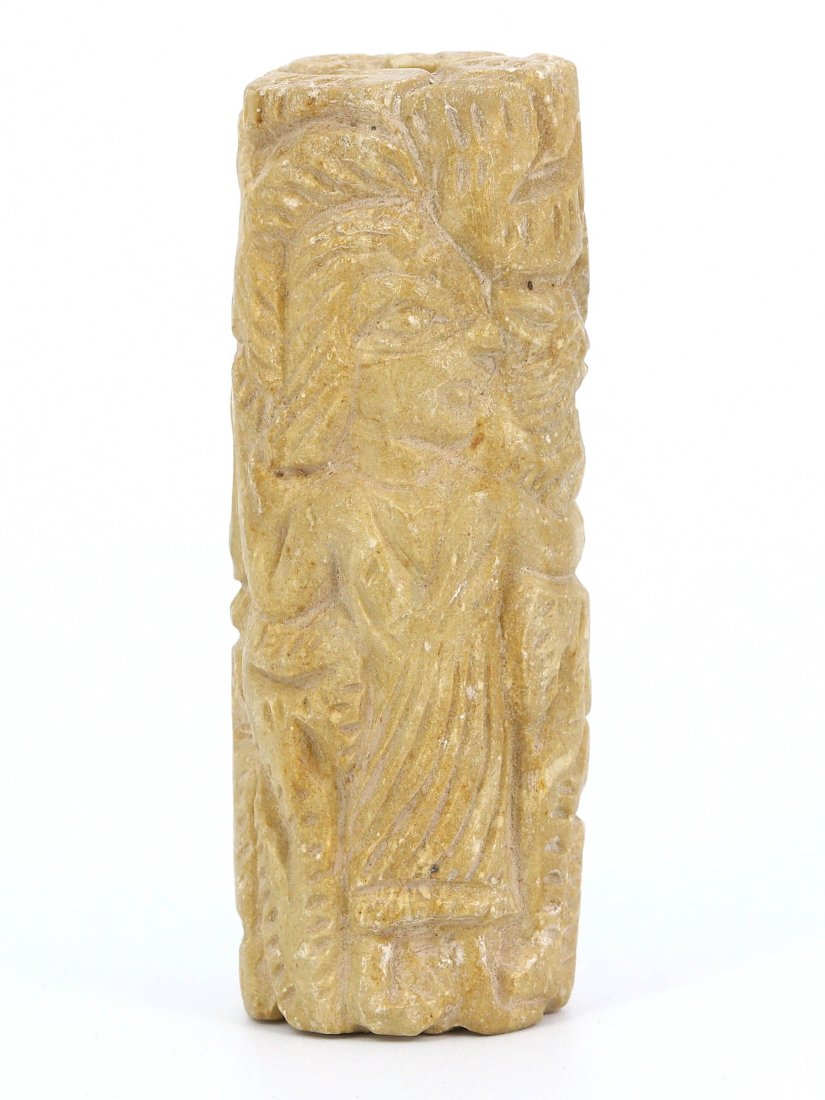 A Byzantine Limestone Cylinder Carving, circa 5th-7th Century A.D.: This elegantly carved limestone cylinder, measuring 6 cm in height and 2.2 cm in diameter, features a relief of a draped figure, possibly a saint or an ecclesiastical figure, indicative of early Byzan
