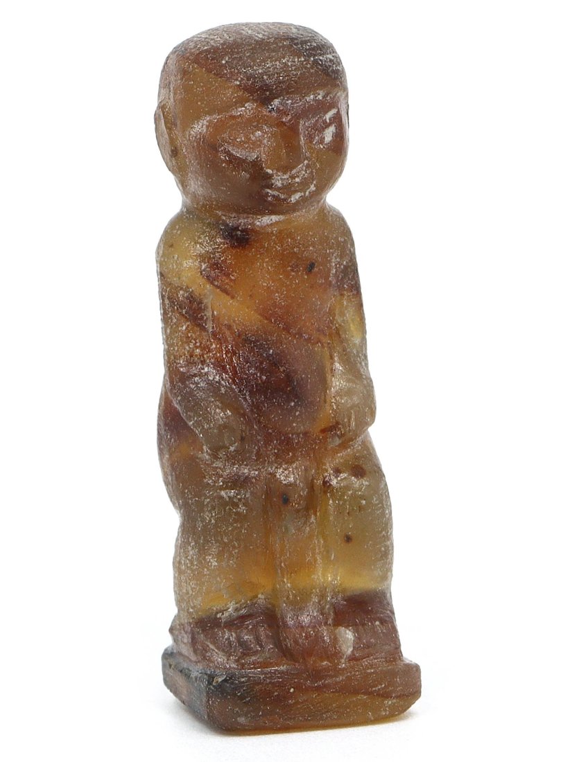 An Ancient Egyptian Carved Figurine Amulet, Post-Pharaonic Period: This diminutive amulet, exquisitely carved to represent a figure, likely of significant cultural or spiritual relevance, is a fine example of Post-Pharaonic Egyptian craftsmanship. The material, exhib