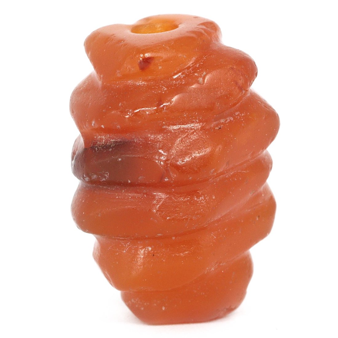 A Sumerian Carnelian Rotund Amulet: This Sumerian carnelian amulet is a relic of profound craftsmanship and symbolism. The rotund shape and warm orange hues of the stone suggest a sun-like significance, possibly invoking the Sumerian su
