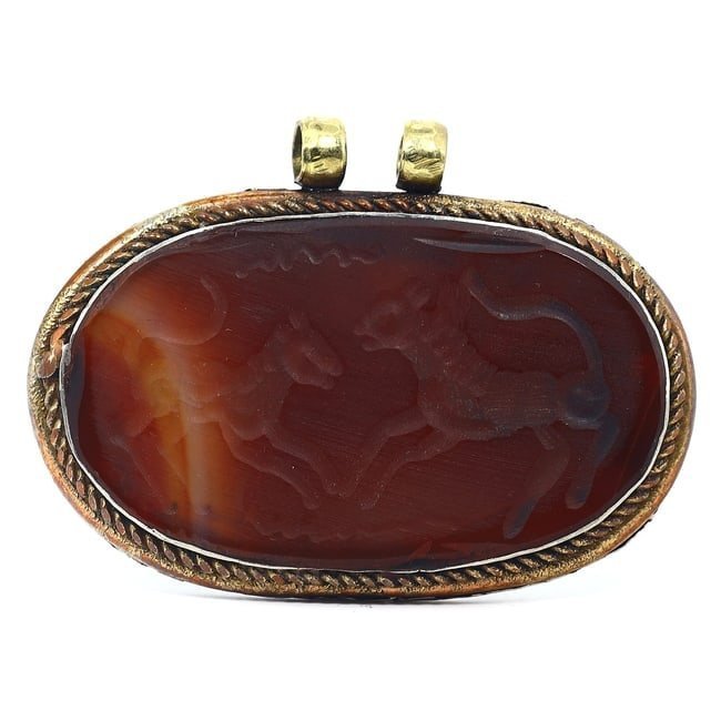 A Silver-Gilt Carnelian Pendant with Hunting Scene: This exquisite silver-gilt pendant, adorned with a carnelian intaglio of a hunting scene, is an emblem of craftsmanship and narrative from a time when such talismans were revered. Measuring 7.5 cm in 