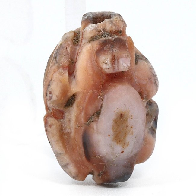An Egyptian Carnelian Agate Scarab Amulet, New Kingdom, 1550-1070 B.C.: This exquisite Egyptian carnelian agate scarab amulet from the New Kingdom period embodies ancient beliefs in rebirth and renewal. The scarab, a symbol of the sun god Ra, is masterfully carved from a 