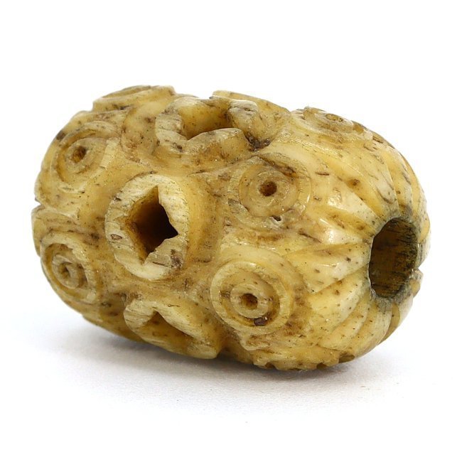 An Ancient Byzantine Intricate Bone Amulet: Discover this ancient Byzantine amulet, a delicate artifact carved from bone, measuring 1.7 by 1 centimeters. Its surface is etched with an array of spirals and circles, possibly symbolic of eternity 