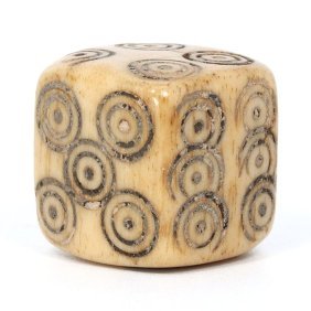 A Medieval Carved Bone Dice, Circa 13th-15th Century: This medieval bone dice, with a height of 1.8 cm and width of 1.4 cm, showcases the leisurely pastimes of bygone eras. Its carefully incised concentric circles on each face represent the meticulous ha