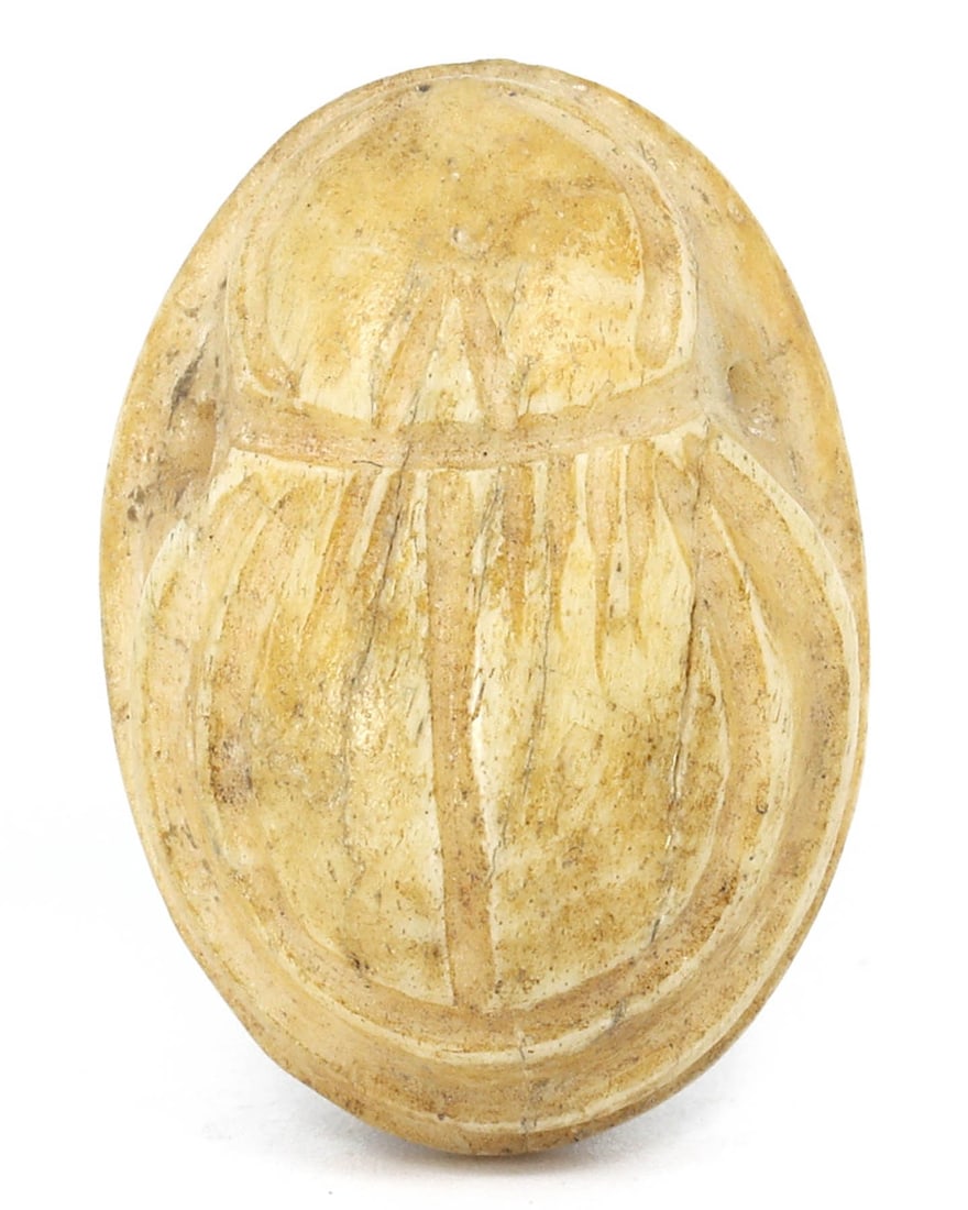 An Ancient Egyptian Bone Scarab Amulet: Unearth the mystique of the ancient Egyptian world with this bone scarab amulet. This piece, measuring a mere 2 by 1.5 centimeters, may have once been an object of profound spiritual significance, sym