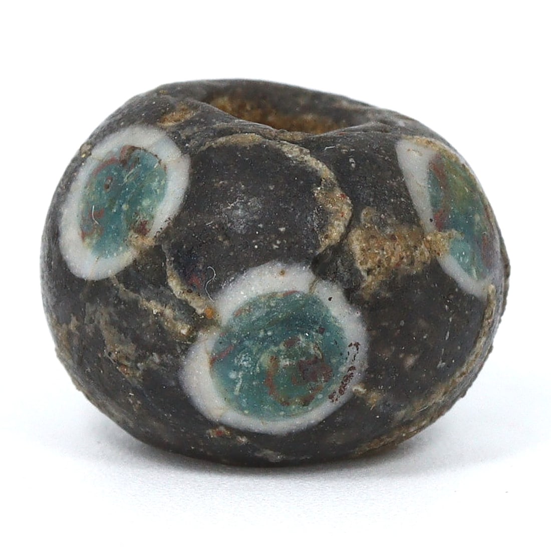 An Ancient Egyptian Glass 'Evil Eye' Bead, Talisman of Protection: This bead, hailing from ancient Egypt, is a striking representation of the 'Evil Eye' an ancient symbol of protection and warding off misfortune. The concentric circles of turquoise and white are enve