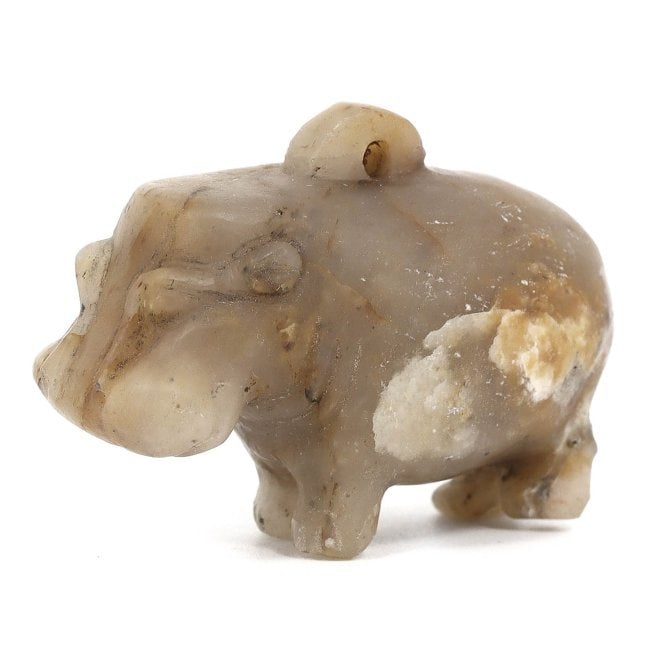 An Ancient Egyptian Calcite Hippopotamus Amulet with Pristine Simplicity: Envision this relic: a calcite amulet of an Egyptian hippopotamus, a creature revered in the ancient Nile civilization. Smooth to the touch, its form is a study in understated elegance, a symbolic gua