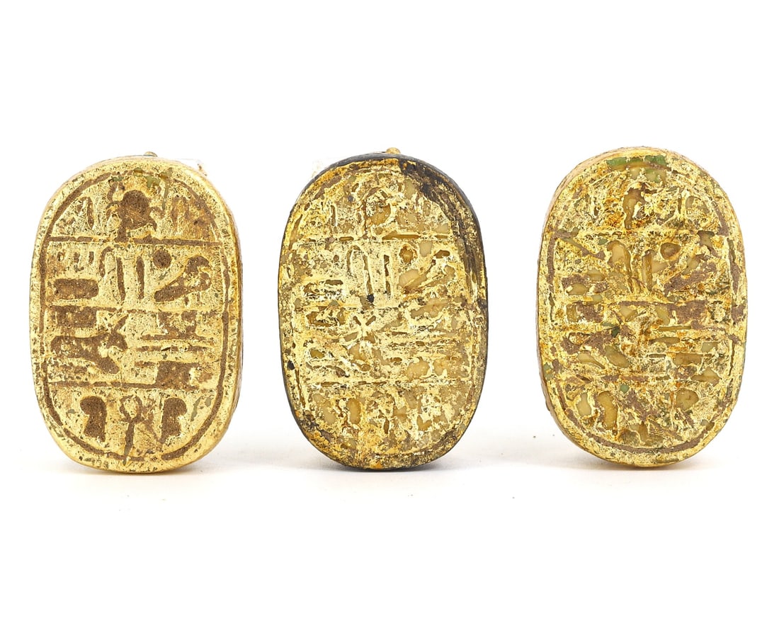 An Ancient Egyptian Golden Stone Scarab Trio: Harking back to the grandeur of Ancient Egypt, this trio of golden stone scarabs lies before us as a testament to the civilization's craftsmanship and religious fervor. In ancient lore, the scarab bee
