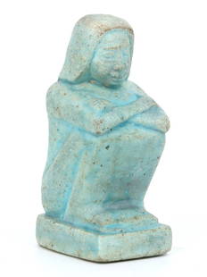 An Egyptian Faience Figurine of a Seated Woman: Enveloped in the calm stillness of eternity, this faience figurine of a seated woman encapsulates the grace and poise of Egyptian craftsmanship. The gentle fold of her arms and the soft tilt of her