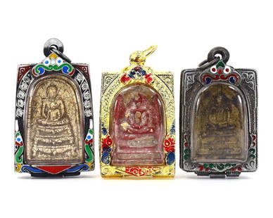 An Assortment of Antique Thai Terracotta Amulets in Ornate Vintage Casings: Discover the intricate beauty of Thai spirituality with this group of three antique terracotta amulets, each enshrined in a vintage casing that accentuates its historical value. The largest amulet mea