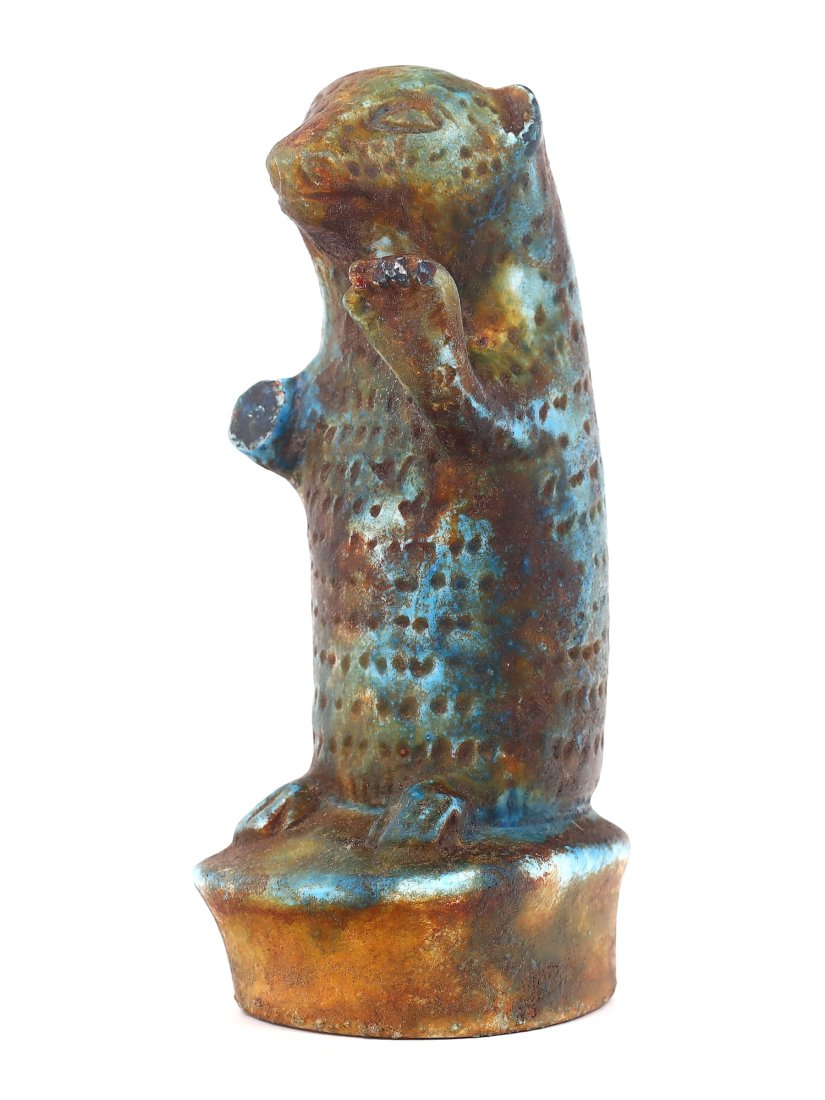 An Egyptian Glazed Steatite Statue of a Fur Seal: This exquisite Egyptian statue captures the form of a fur seal, meticulously crafted from glazed steatite. Standing at a modest 10.5 cm, the figure conveys a sense of naturalistic grace and poise, a t
