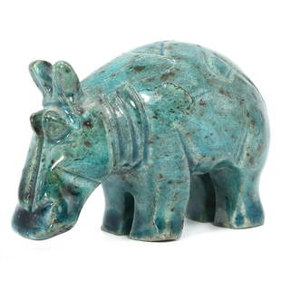 An Egyptian Glazed Steatite Hippopotamus Figurine: Captured in a pose of timeless repose, this glazed steatite hippopotamus figurine carries the tranquil strength of the Nile within its compact 6.5 cm length. The turquoise glaze mirrors the vibrant wa