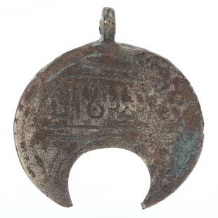 A Viking Bronze Crescent Amulet: This intriguing Viking crescent amulet, measuring 3.5 by 3.1 cm, is a rare artifact reflective of the mystical and seafaring traditions of the Norse people. The bronze composition, adorned with what a