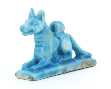 An Egyptian Amulet of Anubis in Repose: This diminutive Egyptian amulet captures Anubis, the jackal-headed god, in a rare moment of repose, a deity's tranquil vigil over the souls of the departed. Cast in the characteristic blue faience, sy