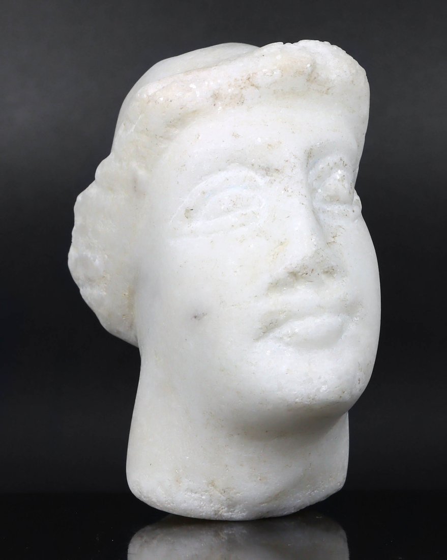 Greco-Roman Marble Head Fragment: This Greco-Roman marble head fragment, is a poignant relic of antiquity. Despite its fragmentary state, the visage retains a dignified serenity, characteristic of the period's portraiture. The marble'