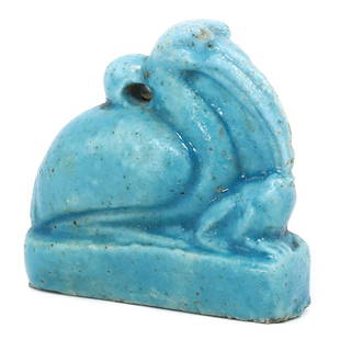 An Egyptian Faience Ibis and Frog Amulet, Late Period: A serene composition in faience, this amulet portrays an Ibis perched alongside a frog, embodying the ancient Egyptian reverence for nature and its sacred animals. The artifact's luminous turquoise co