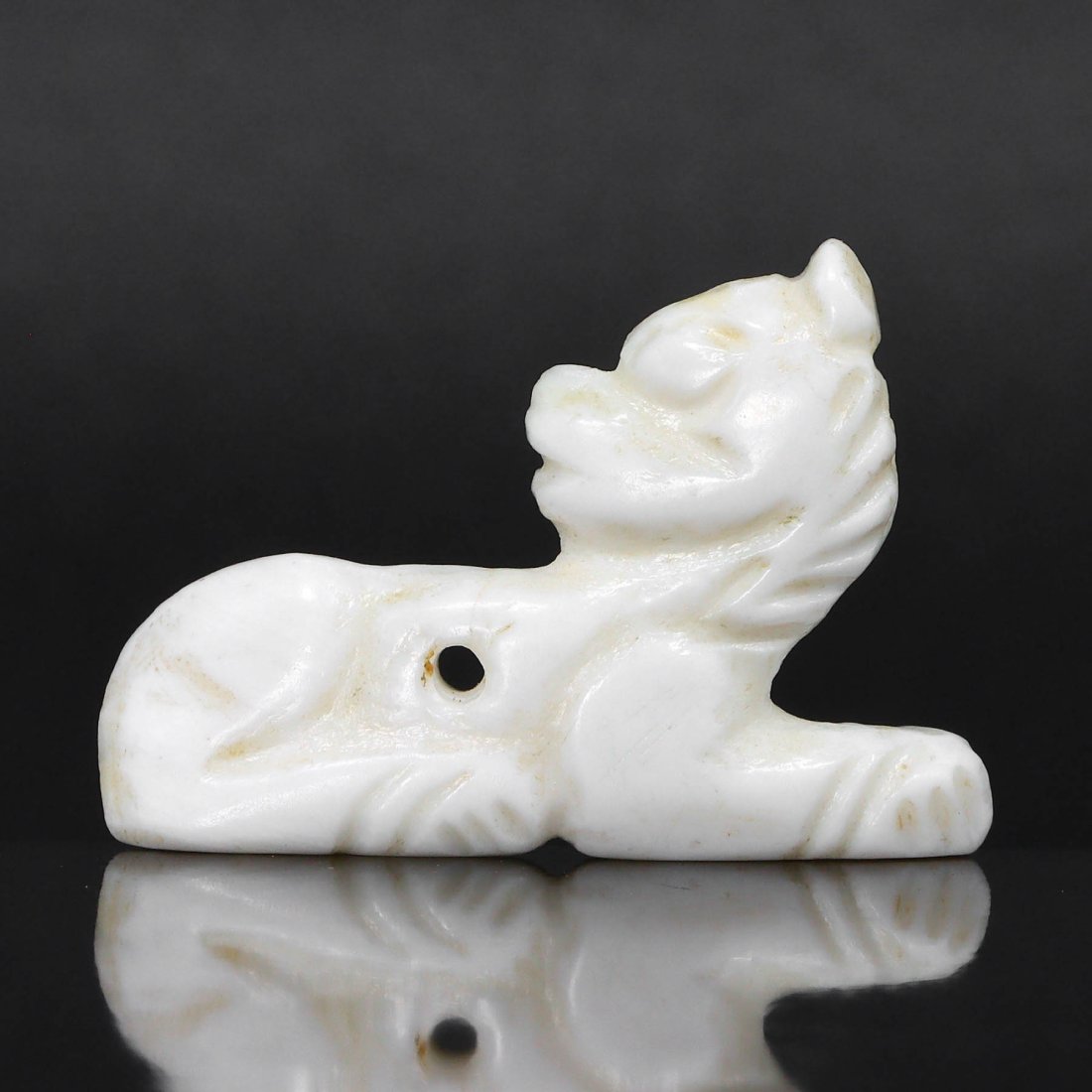 An Egyptian Marble Amulet of a Recumbent Lion: This recumbent lion amulet, crafted from the finest marble, whispers tales of the once-mighty Egyptian civilization. Its form, both regal and relaxed, represents the dichotomy of power and peace withi
