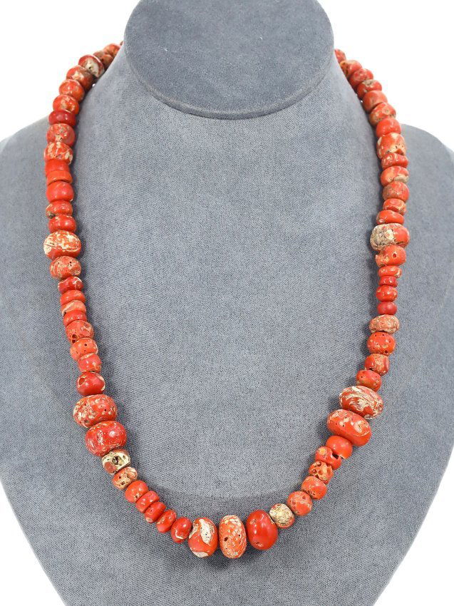 A Tibetan Antique Necklace with Authentic Red Coral Beads: This vibrant strand of red coral beads, measuring 22 inches in length, represents a traditional Tibetan mala, a string of beads commonly used in spiritual practice for keeping count during mantra medi