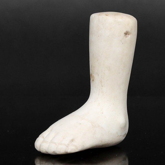 An Ancient Alabaster Leg and Foot Amulet, Probably Egyptian, 1st Millennium BCE: This finely carved alabaster amulet represents the ancient Egyptians' focus on the human form and their belief in the protective power of such charms. The attention to anatomical detail suggests a hig