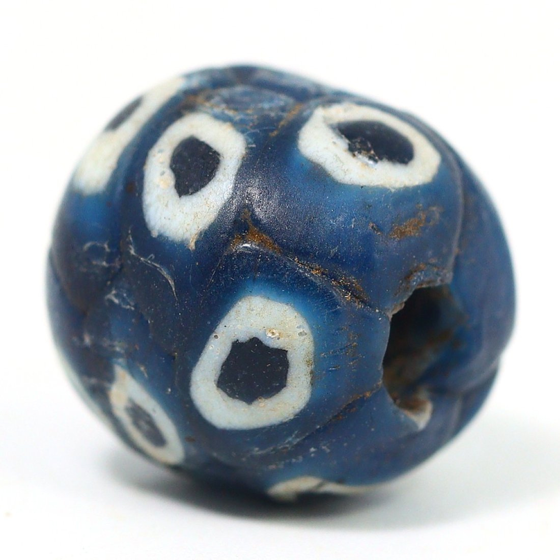 An Antique Islamic Glass Bead with Mosaic Patterns, Circa 8th-10th Century: An exquisite example of Islamic glass craftsmanship, this bead showcases a complex mosaic pattern typical of the early Islamic period. The intricate design, combining dark blue and white hues, reflect