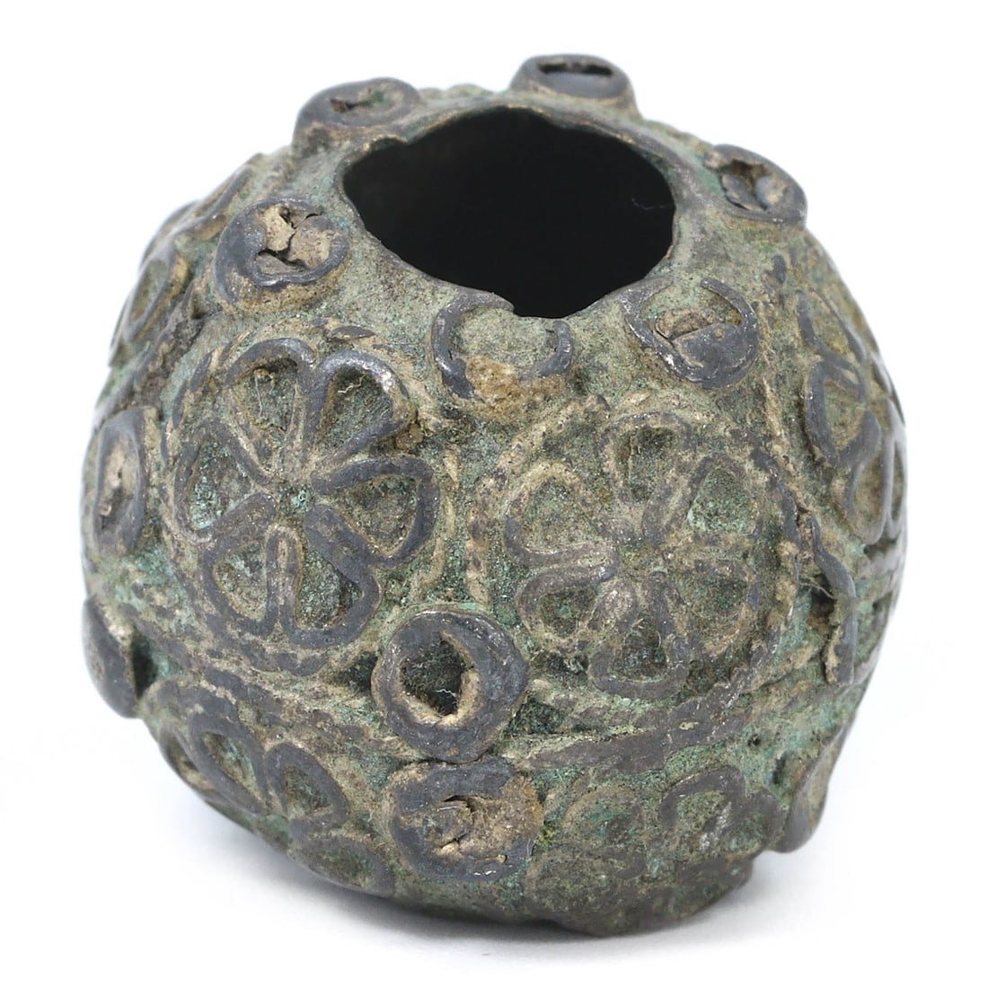 An Ancient Intricate Silver Bead from Persia, 1st Millennium BCE: An ancient Persian silver bead, dating to the 1st millennium BCE, showcasing intricate floral and circular patterns. This bead, measuring 2 x 1.5 cm, was likely used in ancient jewelry or decorative a