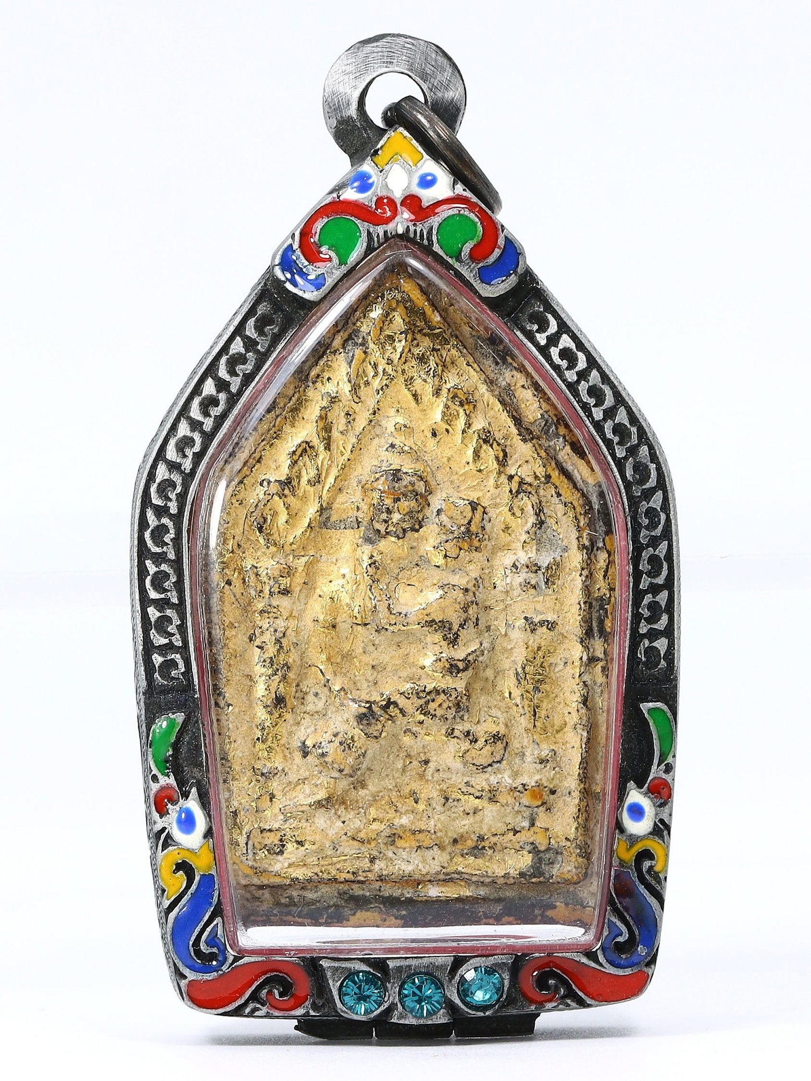 An Ancient Southeast Asian Encased Terracotta Buddha, Pre-15th Century: An object of reverence and meditation, this pre-15th century Southeast Asian terracotta Buddha is encased in an ornate decorative setting with vibrant enamel and inset stones, indicative of the region