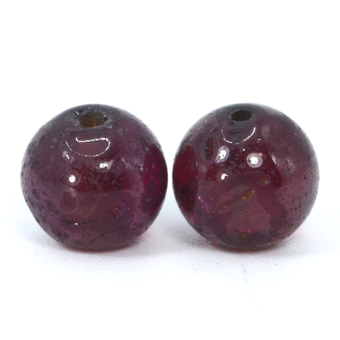 Antique Medieval Red Garnet Bead, c. 8th–15th Century CE: Crafted during the Middle Ages, a time rich in artisanal innovation, this pair of red garnet bead displays the period's shaping skills. Garnets were highly valued for their perceived protective proper