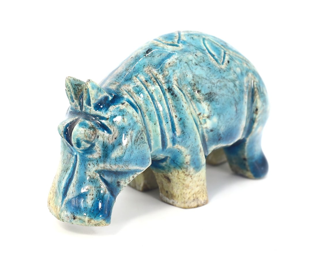 An Egyptian Glazed Steatite Hippopotamus, Late Period/Revival: This vibrant glazed steatite figurine, measuring 6 x 4.5 cm, depicts a hippopotamus, an animal that held significant meaning in ancient Egyptian culture, symbolizing both chaos and fertility. Whether 