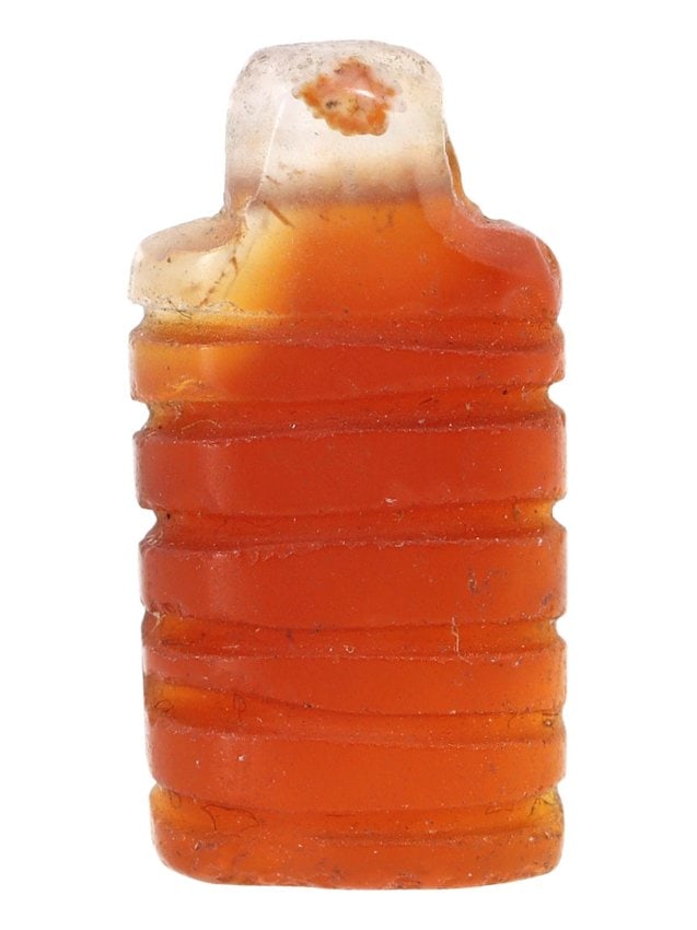 An Ancient Carved Carnelian Bead, Southeast Asia, 1st Millennium BCE: This small but exquisite carnelian bead, measuring 1.9 x 1 cm, features a series of concentric grooves encircling its form—a design characteristic of beadwork from Southeast Asia in the 1st millenni