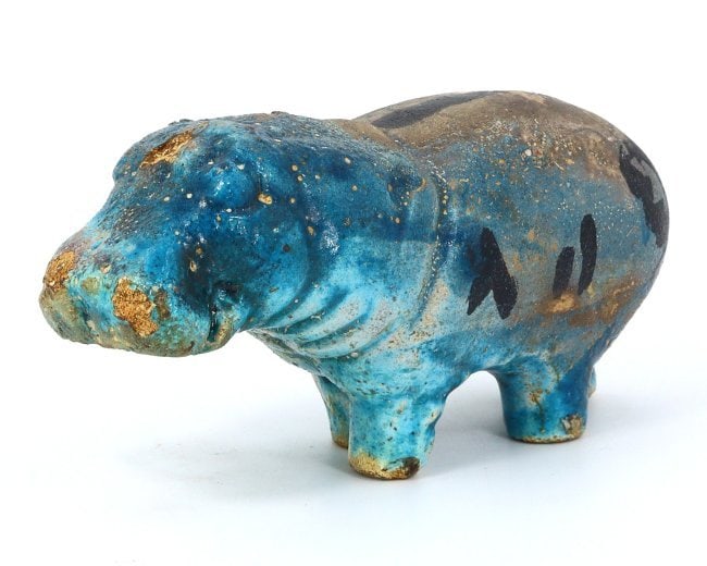 An Egyptian Glazed Steatite Hippopotamus, Late Period/Revival: This vibrant glazed steatite figurine, measuring 14 x 5 cm, depicts a hippopotamus, an animal that held significant meaning in ancient Egyptian culture, symbolizing both chaos and fertility. Whether a