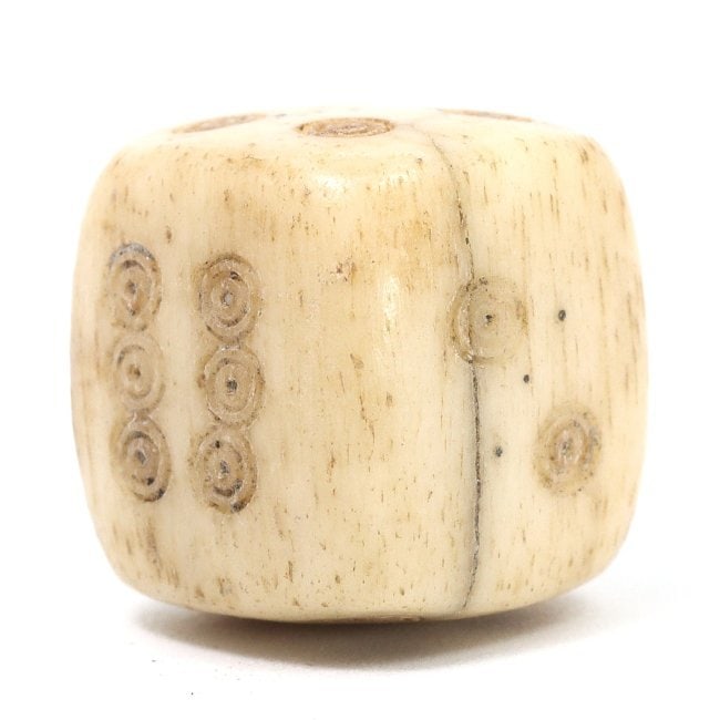 An Antique Bone Dice, Likely Medieval, Circa 13th-15th Century CE: This hand-carved bone dice hails from the medieval period, a gaming artifact that speaks to the period's leisure activities. The dot patterns, etched into the surface, are indicative of the era's nume