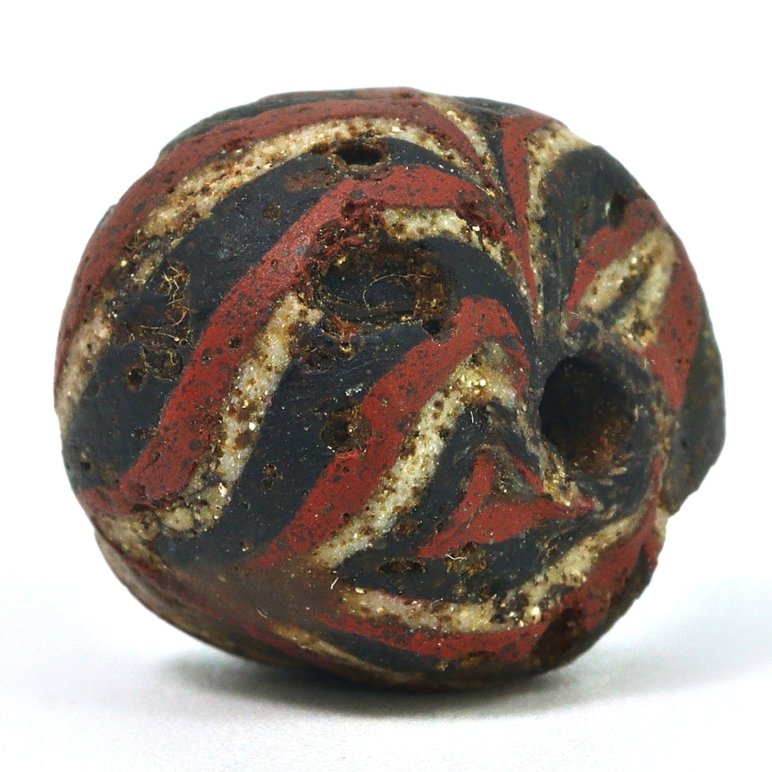 An Ancient Islamic Chevron Glass Bead, Circa 9th-11th Century CE: This glass bead, featuring the distinctive chevron pattern, is indicative of Islamic art from the 9th to the 11th century CE. Chevron beads were crafted using a multi-layered glass technique, highly p