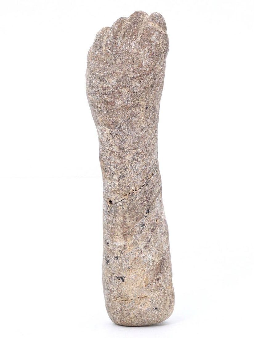 An Ancient Egyptian Fist Amulet, Circa 1st Millennium BCE: This stone amulet, carved in the shape of a clenched fist, is emblematic of Egyptian symbolism, where such gestures were often associated with strength and protection. Its simplistic yet powerful form