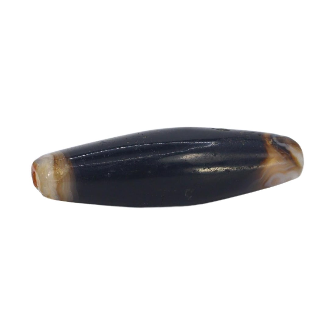 An Ancient Tibetan Banded Agate Chung Dzi Bead, 6th-10th Century AC: This chung dzi bead, with its enigmatic dark hues and stark banding, is a quintessential artifact of Tibetan culture. Dzi beads are deeply rooted in Tibetan tradition, often used as protective amulets