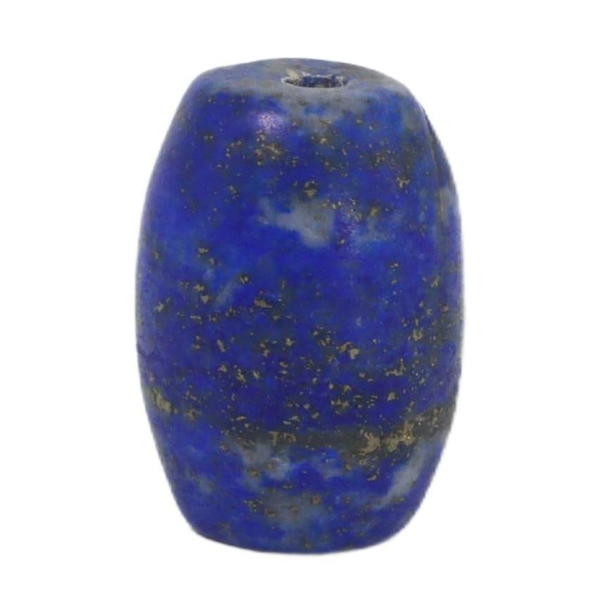 Ancient Mesopotamia Neo-Babylonian Lapis Lazuli Bead, c. 626-539 BCE: This bead, carved from the treasured lapis lazuli, is a remnant of the Neo-Babylonian period, reflecting the luxury and ritual significance associated with the stone in that era. Lapis lazuli was este