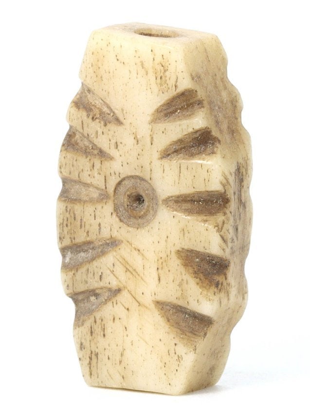 An Antique Viking Carved Bone Bead Amulet, Circa 8th-11th Century CE: This intricately carved bead made from bone features a radial pattern, a decorative motif common in the Viking Age, ranging from the 8th to 11th centuries CE. The Vikings were known for their skilled