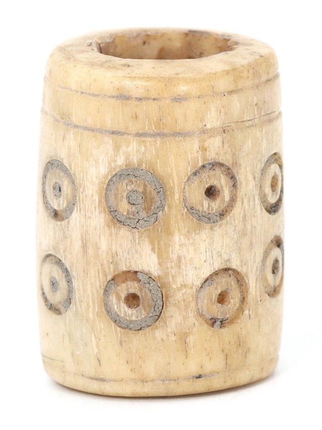 An Antique Medieval European Carved Bone Bead Amulet, Circa 10th-12th Century CE: This bead, carved from bone and adorned with concentric circles, is representative of the artistic expression found in Medieval Europe, specifically from the 10th to the 12th century CE. The dot-and-c