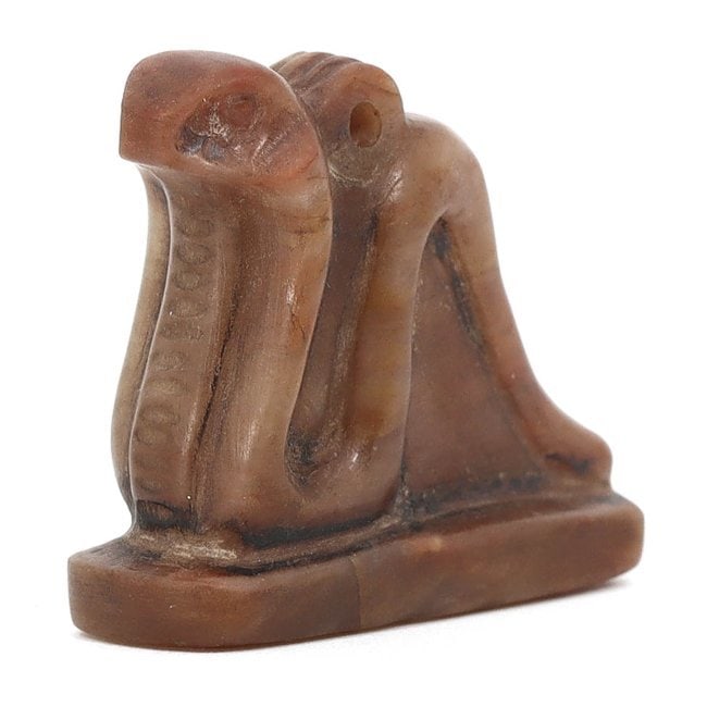 An Ancient Egyptian Alabaster Uraeus Serpent Amulet, Late Period, Circa 664-332 BCE: This alabaster amulet, standing at 3 x 2.5 cm, represents the Uraeus, a symbol of sovereignty, royalty, and divine authority in ancient Egypt. The cobra, depicted in a rearing position, was worn by ru