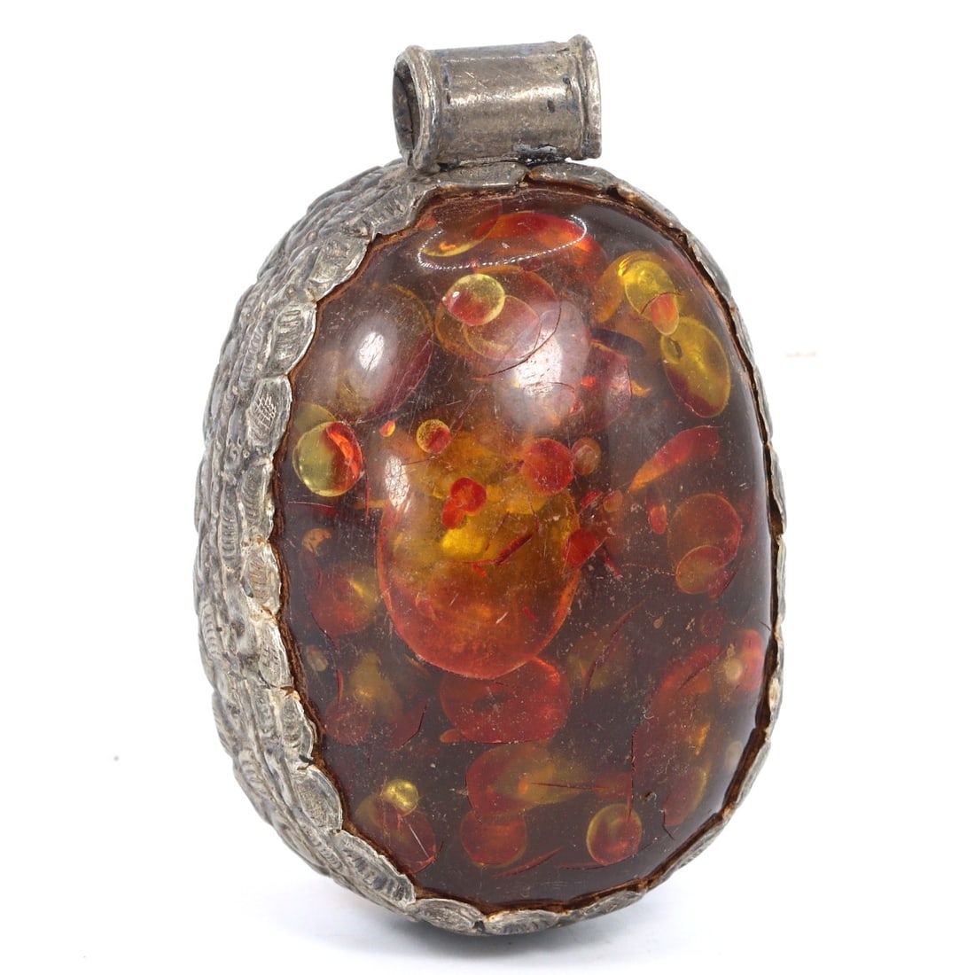 Vintage Himalayan Tibetan Pressed Amber Pendant, Modern Era: This stunning pendant, originating from the Himalayan Tibetan region, is crafted from pressed amber, encapsulating vibrant red and yellow inclusions that create a mesmerizing visual effect. The silver