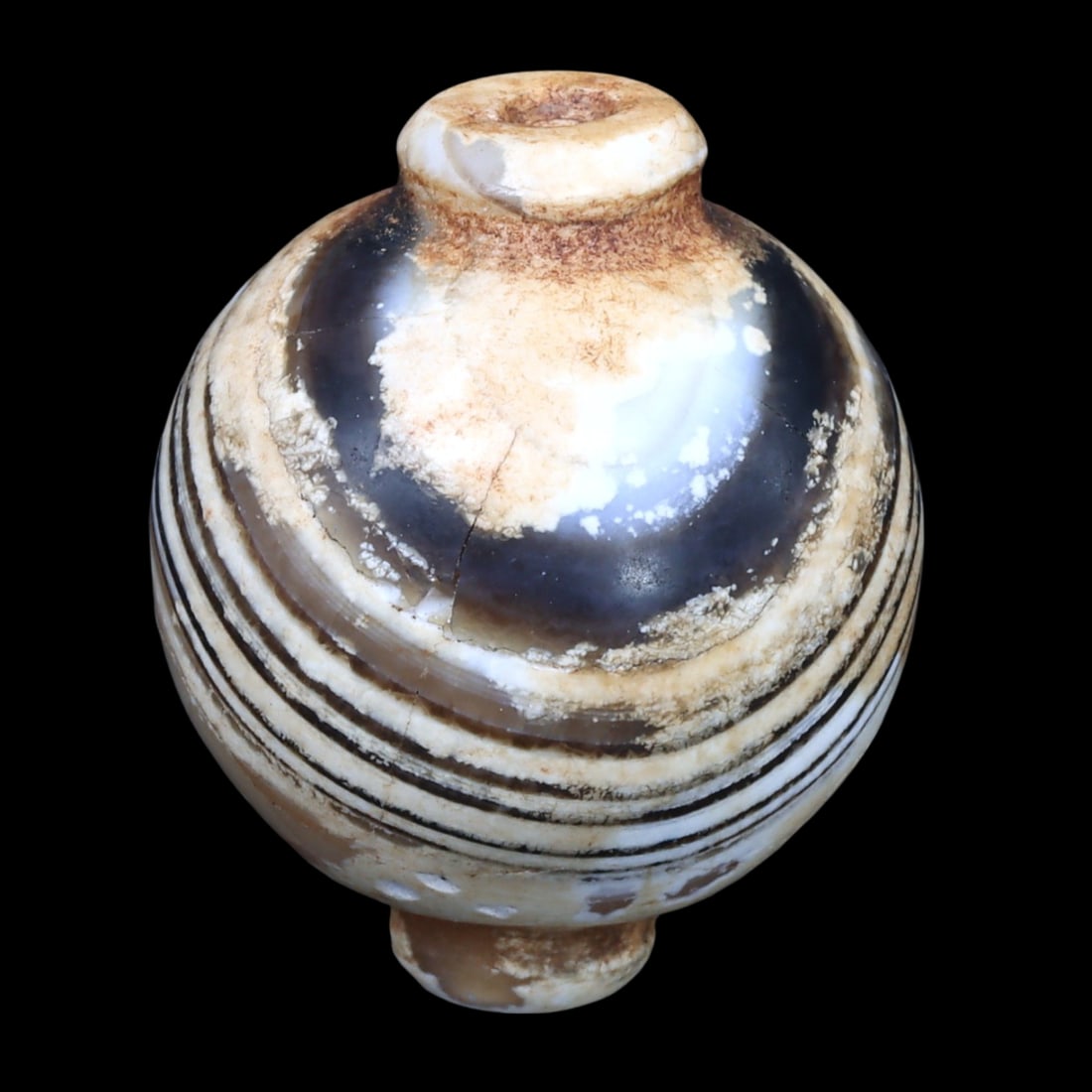 Greco-Bactrian Banded Carnelian Concave Bicone Bead, ca. 3rd-2nd Century BCE: This Concave Bicone carnelian bead, characterized by its distinct banded pattern, hails from the Greco-Bactrian period. The bead's design features alternating bands of opaque white and translucent dee