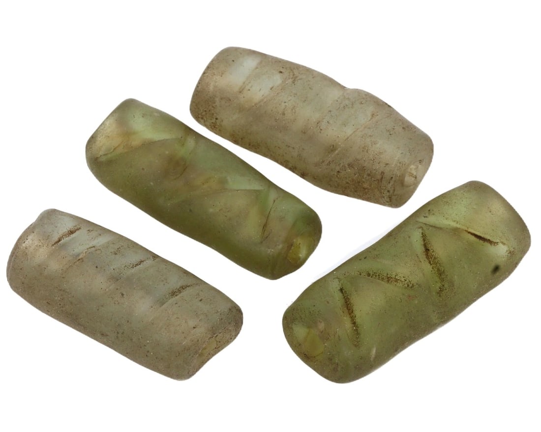 Collection of Ancient Byzantine Glass Beads, 6th-7th Century CE: This set of glass beads dates back to the Byzantine era, specifically the 6th to 7th century CE. Characterized by their deep green and sandy hues, these beads illustrate the sophisticated glass-making