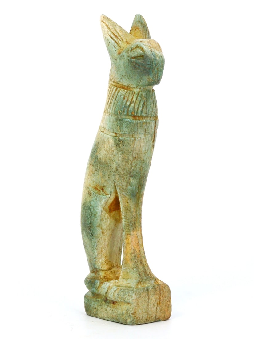 An Antique Egyptian Revival Faience Bastet Figurine, c. 19th Century CE: This faience figurine of Bastet, dating from the 19th-century Egyptian Revival, mirrors the Late Period's style. It showcases Bastet's dual nature as a goddess of home and protector, emphasizing the a