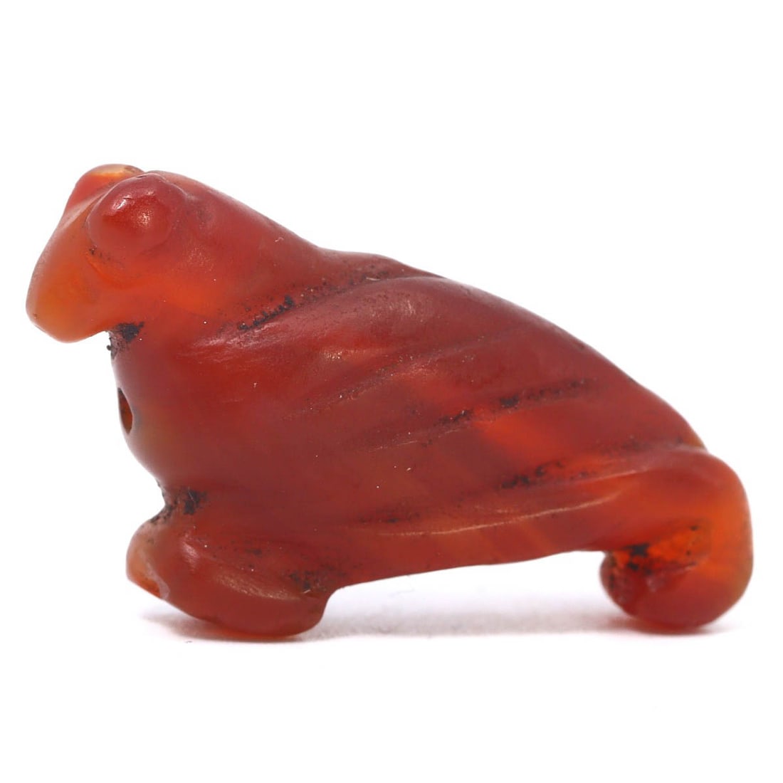 An Ancient Coptic Egyptian Carnelian Bird Form Amulet, 3rd-6th Century CE: This Coptic Egyptian carnelian amulet, shaped like a bird, dates from the 3rd to the 6th century CE. The bird motif, symbolizing the soul's ascent to heaven, reflects the spiritual beliefs of the Copt